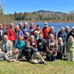 A large group of people in front of a lake