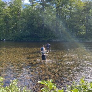 hikers crossing a river