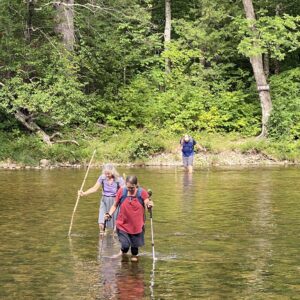 hikers crossing a river