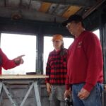 On June 3, 2016, Earl, on the left, explains how a Fire Watchman would use the map table and alidade to accurately locate any potential fire within the 360˚ view of the Fire Lookout on Deasey Mountain. Photo courtesy of Chunzeng Wang.