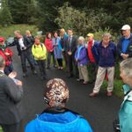 In October 2016, Earl and Maureen are in the midst of a scrum of U.S., Canadian, and Irish delegates at Kelly's Bridge between County Donegal in the Republic of Ireland (foreground) and County Tyrone in Northern Ireland (background), listening to the well-wishes of the mayors of Donegal Town, Ireland and Strabane, Northern Ireland upon the completion of the IAT on the island of Ireland.